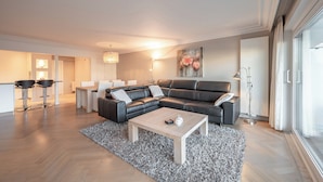 Een moderne woonkamer met een modulaire bank, een salontafel en een kamerkleed met patroon.