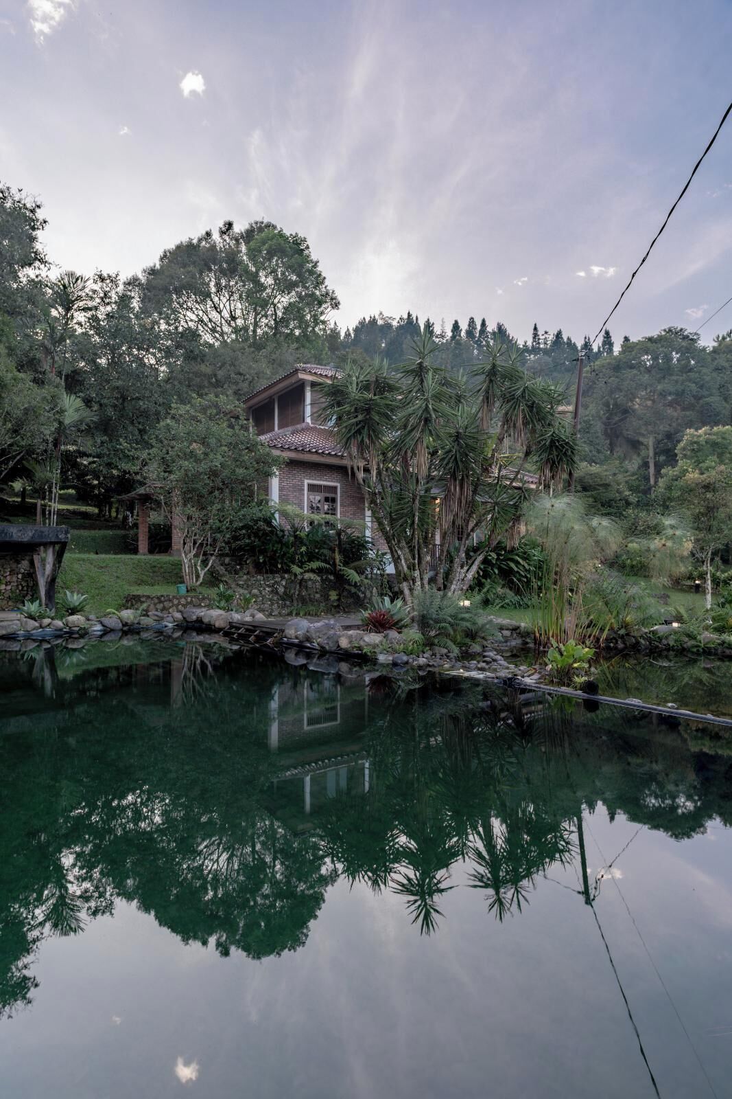 A house with a garden and a pond.