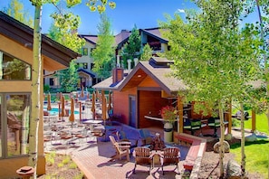 Un patio con mobiliario exterior y una piscina.