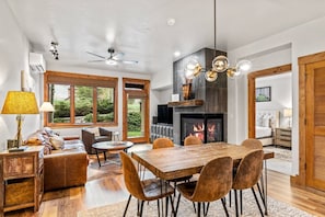 A spacious living area with a fireplace, dining table, and comfortable seating.