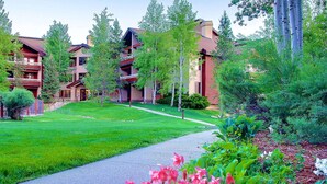 A hotel with multiple balconies, a well-maintained lawn, and a pathway.