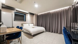 Una habitación de hotel moderna con una cama, un escritorio y una silla.