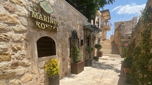 A stone building with a sign reading "MARINUT KOVACI". - Marinut Konağı (Mardin)