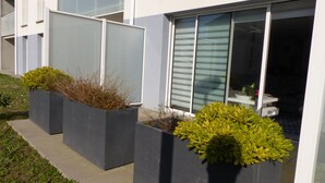 A modern building with large grey planters containing green shrubs. - Ty Kerihuel - Luxury flat on the port in Etel (Etel)