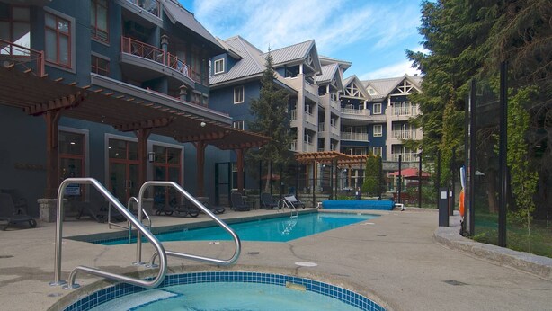 A hotel with a swimming pool, outdoor seating, and a covered patio area. - Village Studio at Alpenglow. Steps away from everything.
Pool and hot tub (Whistler)