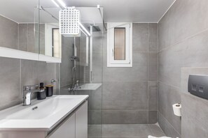 Apartamento básico, 2 quartos, cozinha, vista para a cidade | Banheiro | Chuveiro, chuveiro com efeito de chuva, produtos de toalete grátis 