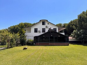 Un edificio de dos plantas con techo plano, ventanas grandes y un porche cubierto.