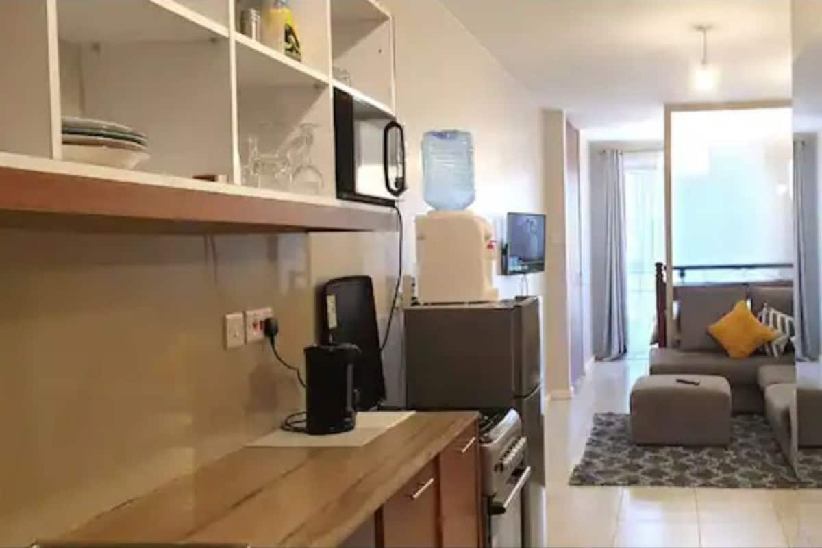 A compact living space with a kitchenette, a sofa, and a small dining area.