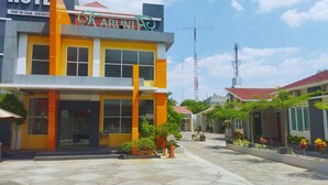 A hotel named "Karinti" with a modern architectural design, featuring large windows and a prominent orange and yellow facade. - Hotel Karunia PKPRI (Purwodadi)
