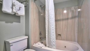 A bathroom with a bathtub, toilet, and towel rack.