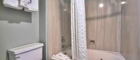 Un baño con bañera, inodoro y toallero.