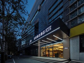 A modern hotel entrance with a glass facade and illuminated signage. - HomeInn Plus Guozhan Liufang Subway Stn (Beijing)