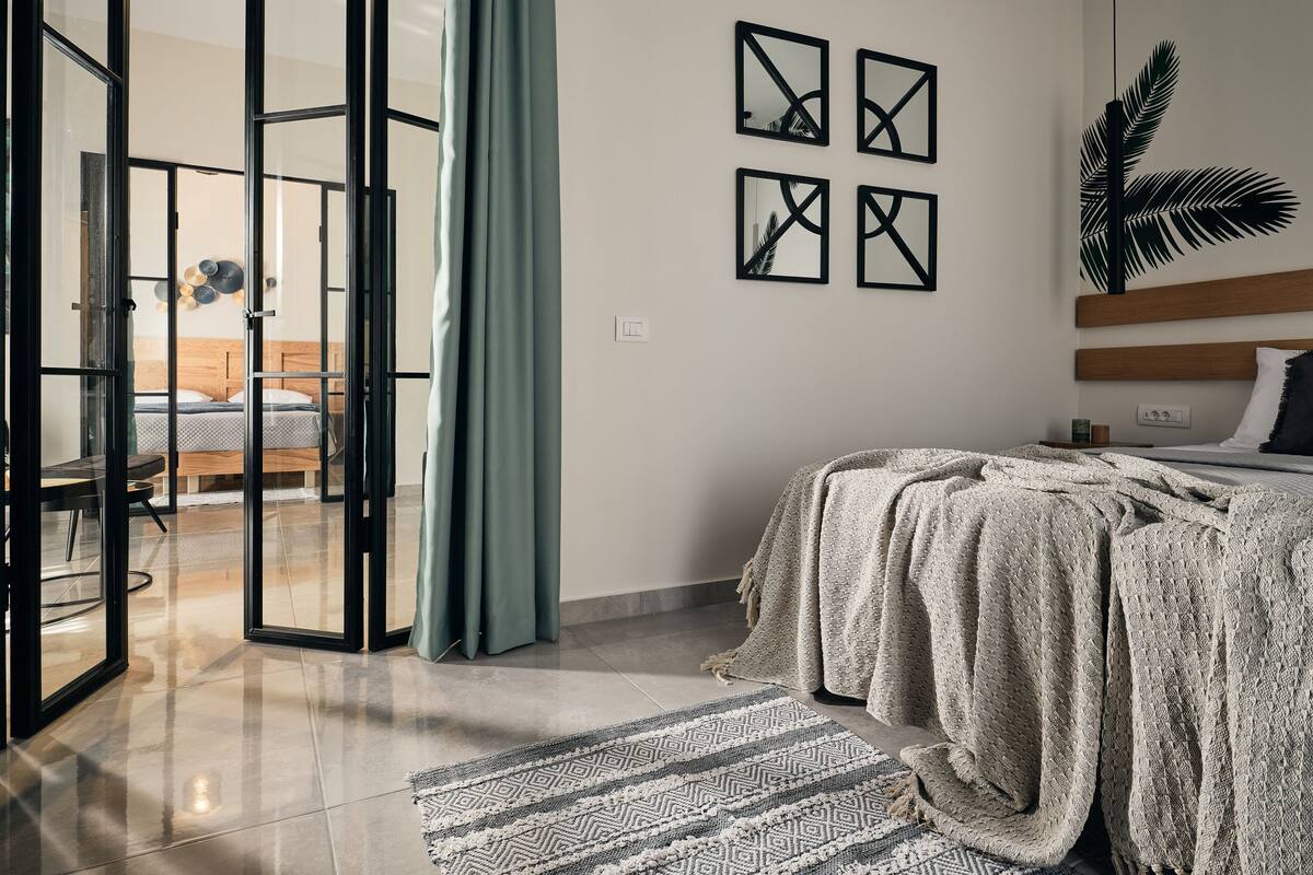Une chambre à coucher moderne, avec un lit, une grande fenêtre et une vue sur une autre pièce.