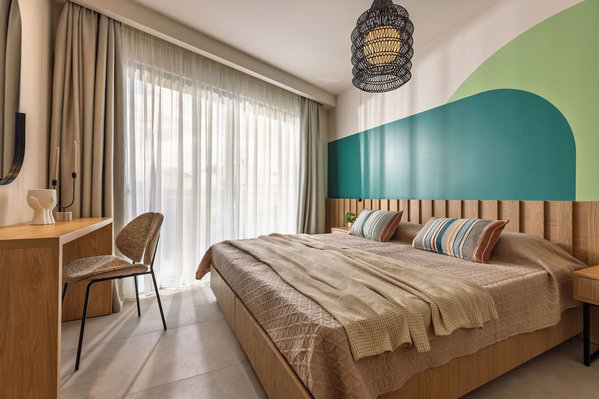 Une chambre d’hôtel moderne, dotée d’un grand lit, d’un bureau et d’une chaise.