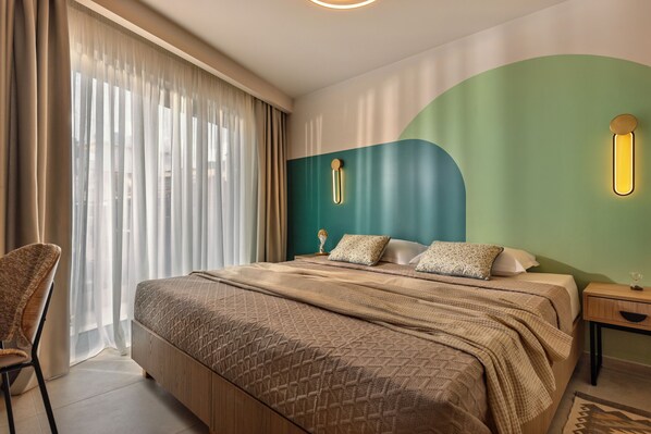 Una habitación de hotel con una cama, una silla, una mesita de noche y una lámpara fijada a la pared.