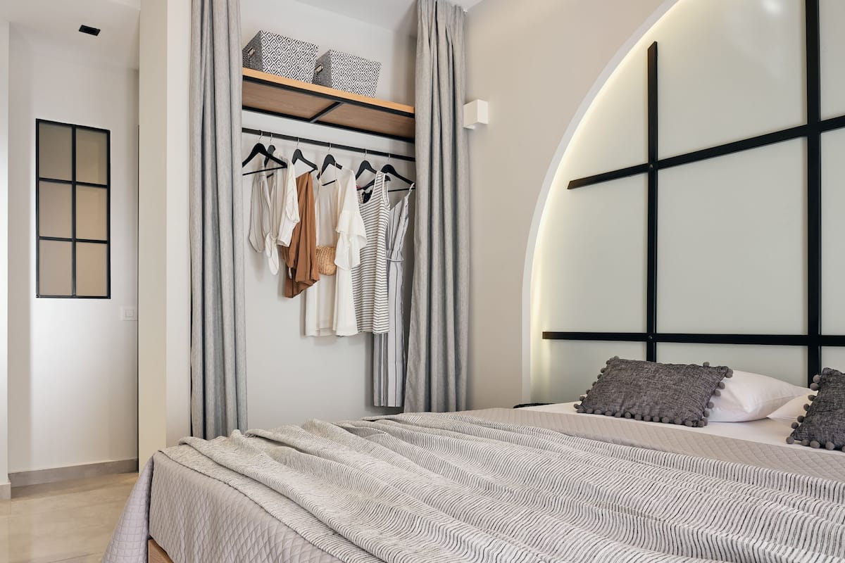Une chambre à coucher moderne avec un lit, une armoire et un portant à vêtements.
