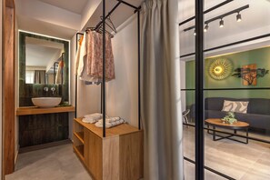 Un baño moderno con tocador de madera, un espejo grande y un perchero para toallas.