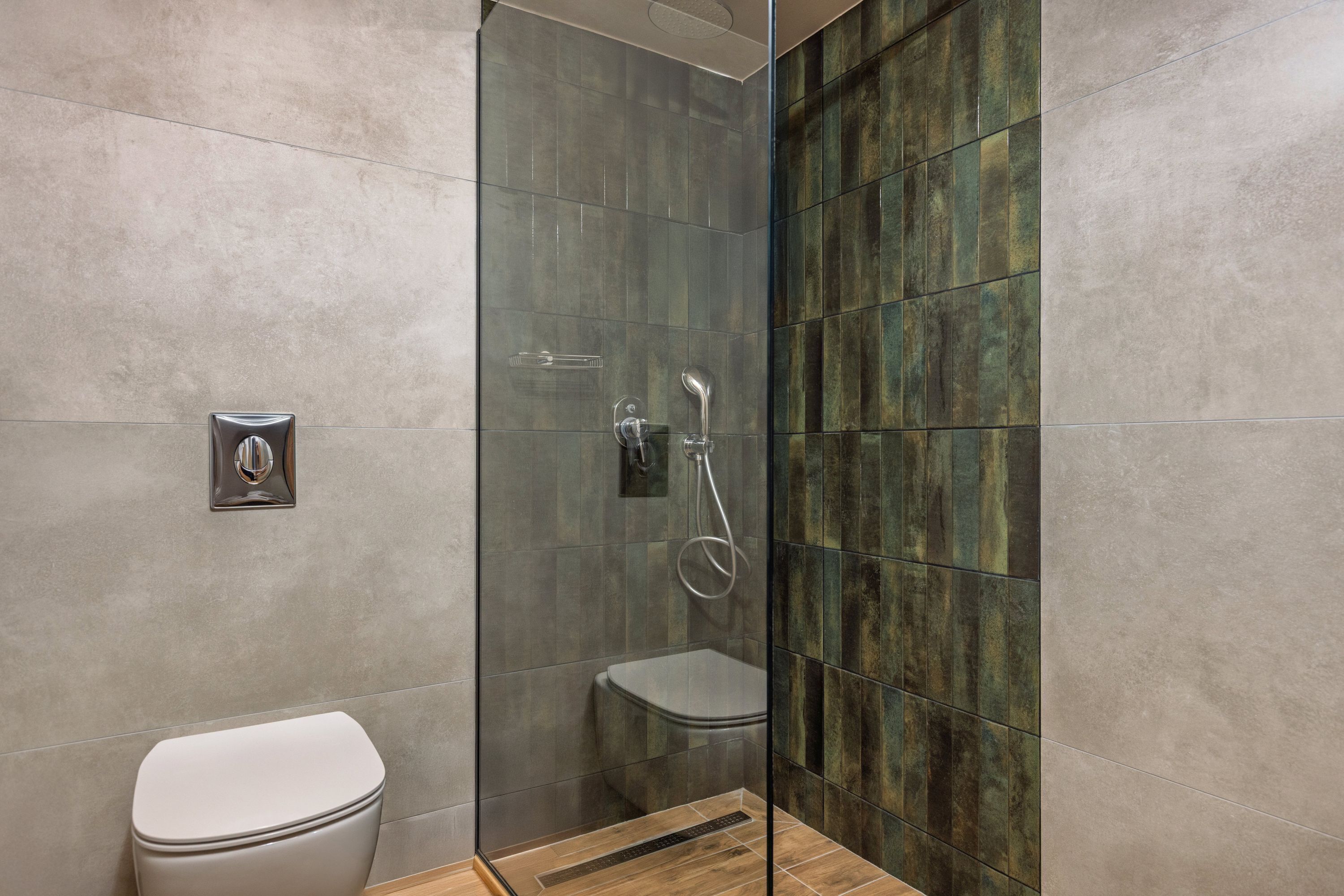 A modern bathroom with a glass shower enclosure, a toilet, and a sink.