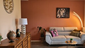 A living room with a sofa, a globe, a lamp, and a painting on the wall.