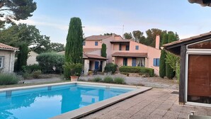 A residential property with a swimming pool, a patio area, and a garden with various plants. - House in Provence (Chateauneuf de gadagne)