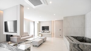 A modern living room with a large TV, a fireplace, and a sofa. - Gyeongju city hotel (Gyeongju)