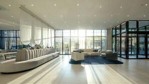 A spacious lobby with a long, curved seating area and a coffee table. - Gyeongju city hotel (Gyeongju)
