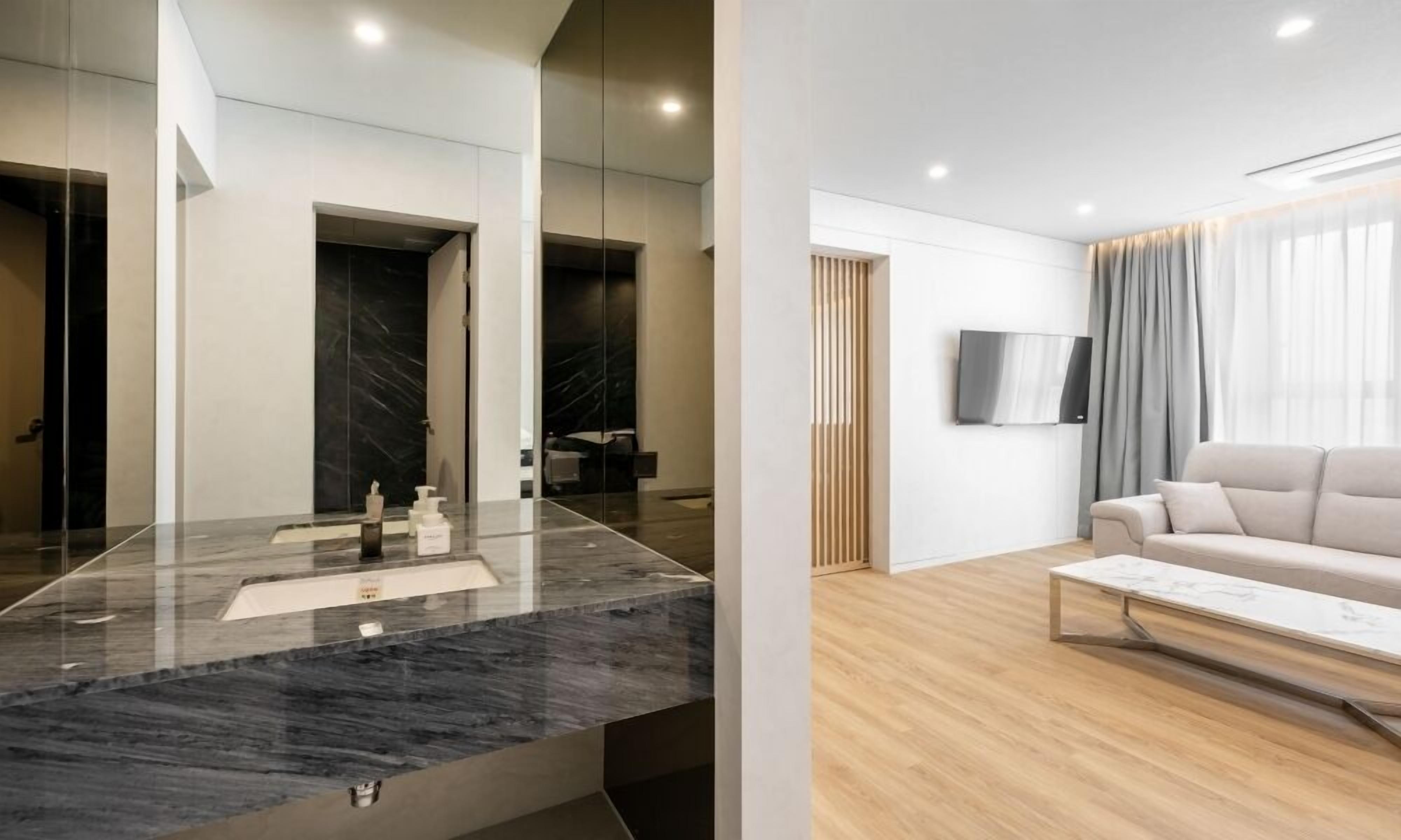 A modern bathroom with a marble sink and a large mirror.