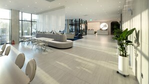 A modern hotel lobby with a seating area, a reception desk, and large windows. - Gyeongju city hotel (Gyeongju)