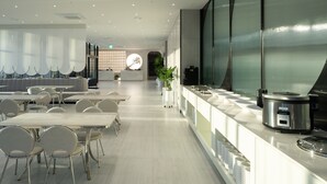 A modern restaurant with a long counter, seating area, and a large decorative window. - Gyeongju city hotel (Gyeongju)