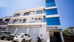 A multi-story building with a sign for Meraki Inn. - Hotel Meraki Inn (Lucknow)