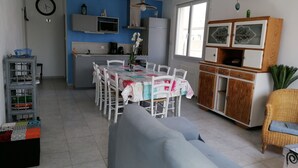 Une cuisine moderne équipée d’un four à micro-ondes, d’une cuisinière et d’un évier. Un coin repas avec une table et des chaises est également disponible.