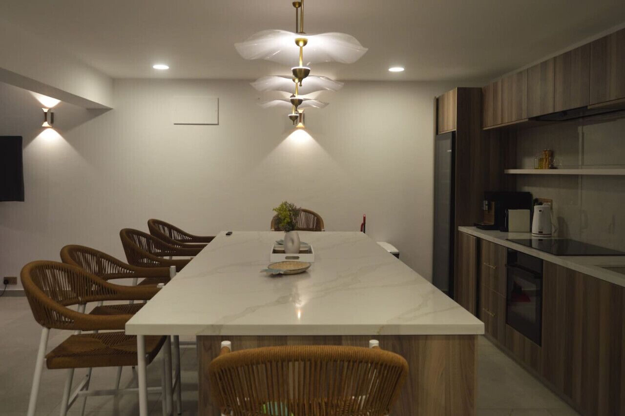 Une cuisine moderne dotée d’un grand îlot central, de meubles en bois et d’un four encastré.