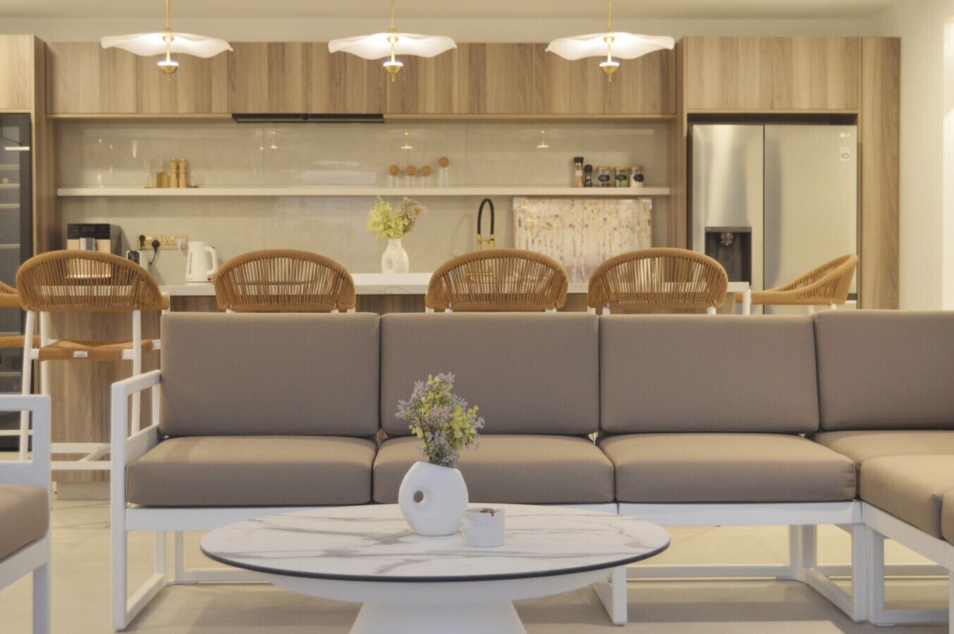 A modern kitchen with wooden cabinets, a built-in oven, and a stainless steel refrigerator.