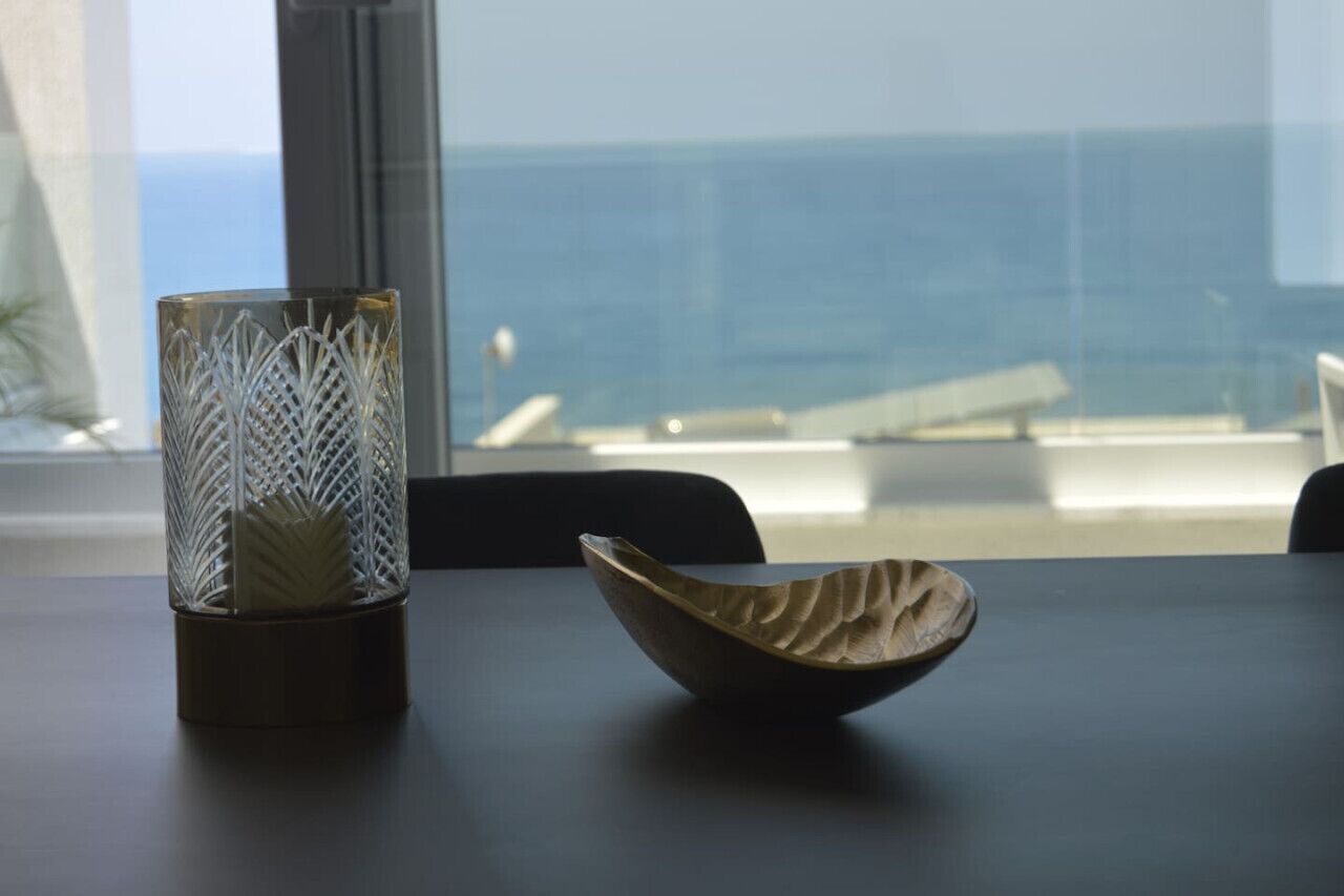Una mesa con un jarrón de vidrio y un cuenco de madera.