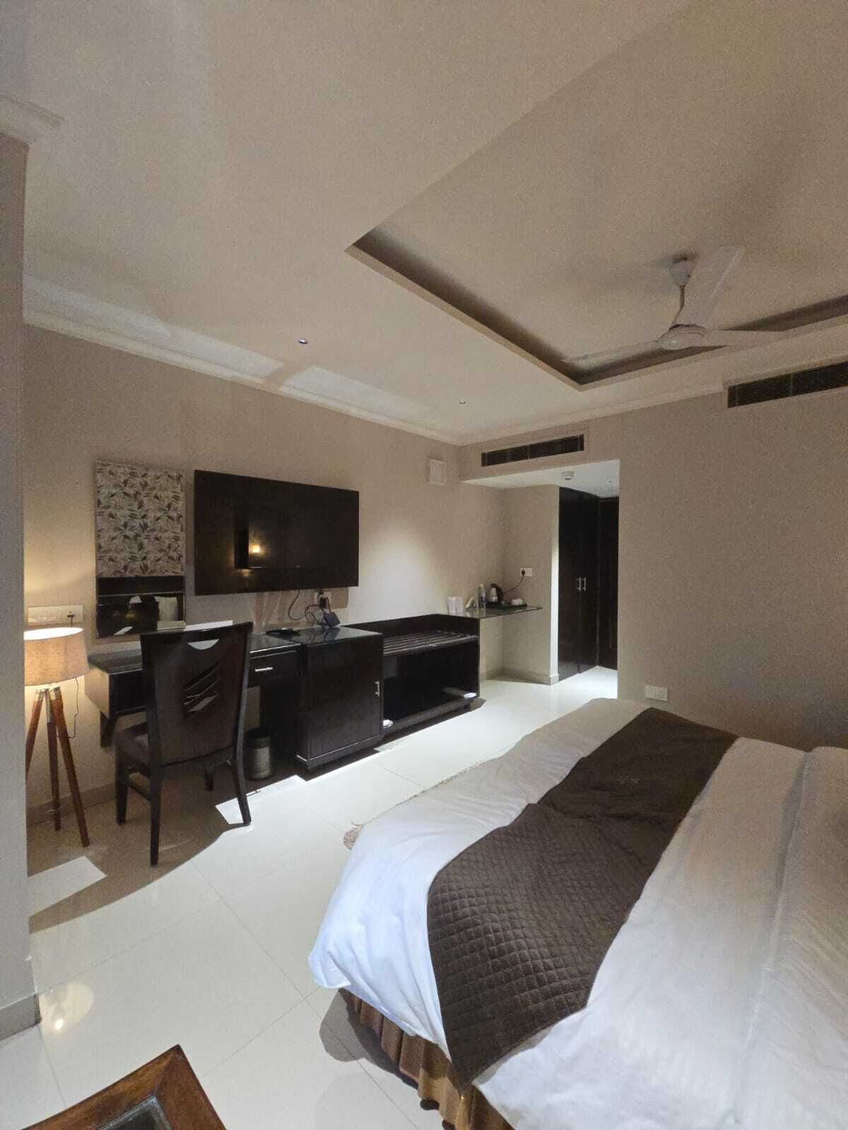 Een moderne hotelkamer met een groot bed, een bureau en een flatscreen televisie.