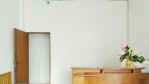 Une pièce avec un comptoir d’accueil en bois, un banc et une porte.