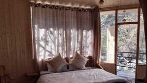 Une pièce en bois avec un lit, des rideaux et une fenêtre.