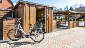 A wooden building with a bicycle parked in front. - Apartment 'Wattlöwe Tönning' with Private Terrace, Private Garden and Wi-Fi (Tönning)