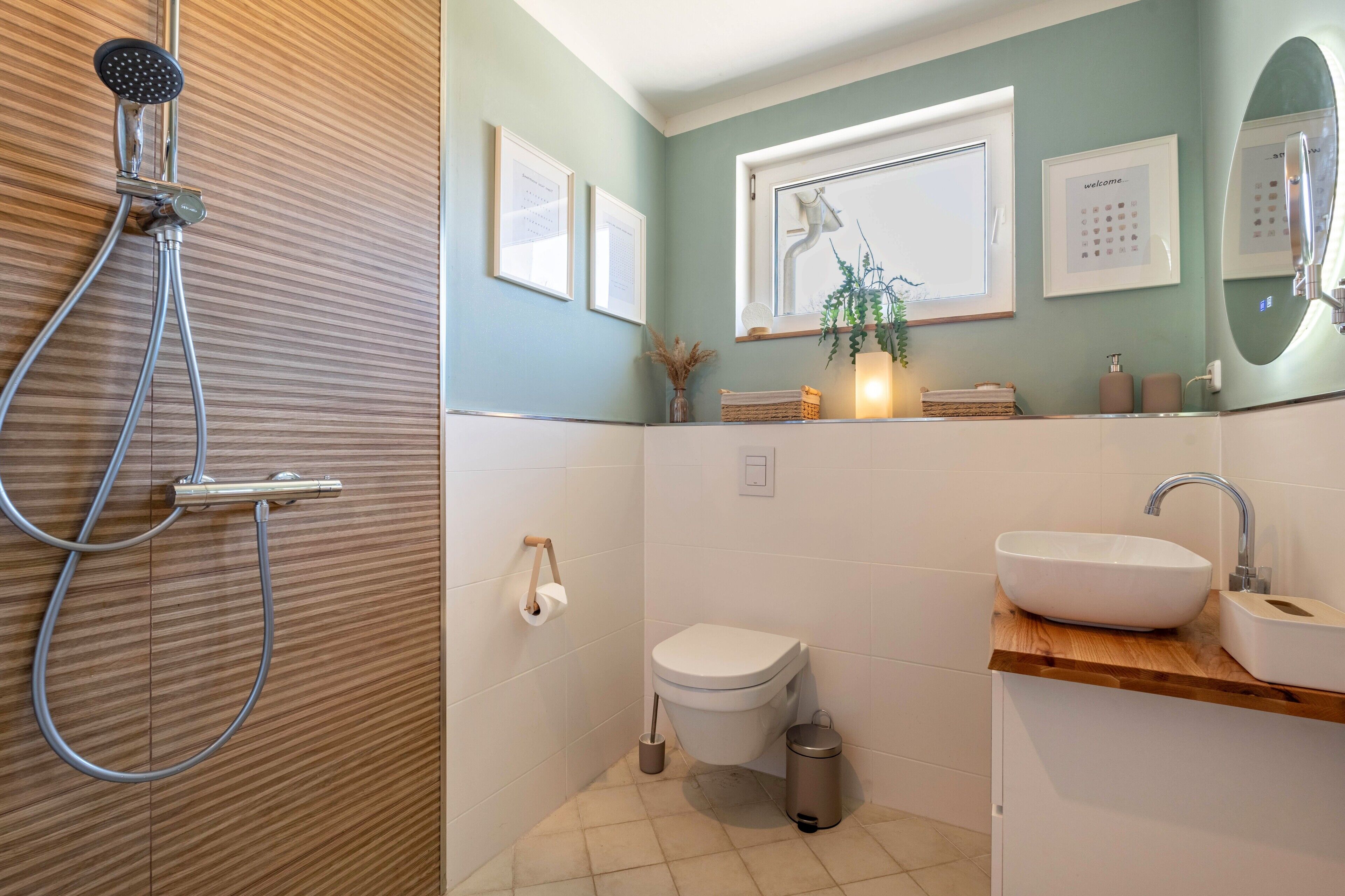 Une salle de bain équipée d’une douche, de toilettes, d’un lavabo et d’un miroir.