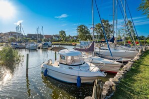 A marina with boats docked along a grassy embankment.