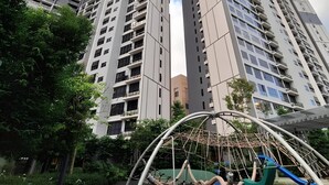 A high-rise building with multiple floors, surrounded by greenery and a playground structure. - Agile Residence Dual-Key Gem @ Bukit Bintang F16 By Natol (Kuala Lumpur)