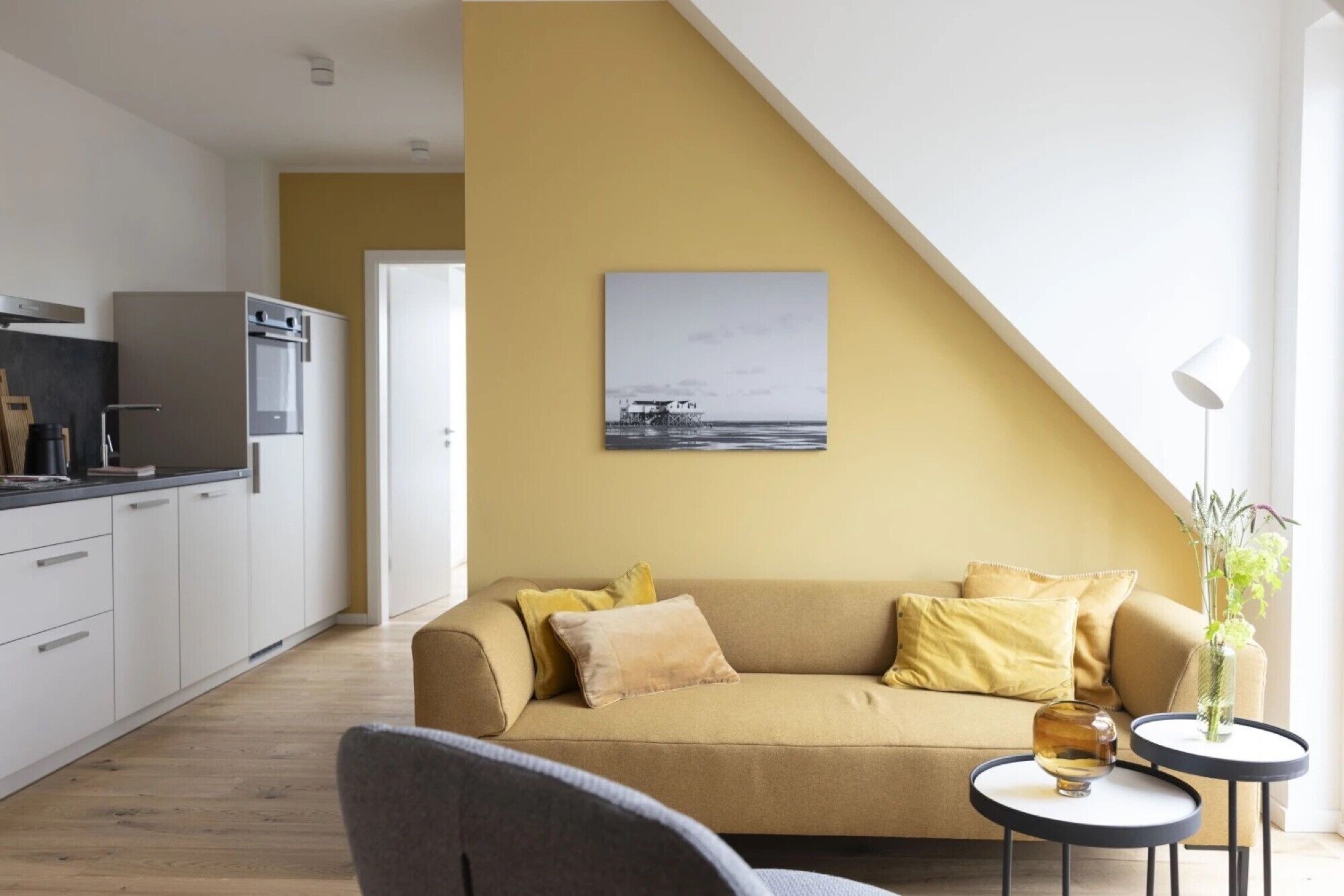 A modern living room with a sofa, a coffee table, and a painting on the wall.