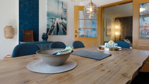 A dining table with a bowl, placemats, and a decorative centerpiece. - Holiday Home 'Ankerglück' with Private Terrace and Wi-Fi (Lensahn)