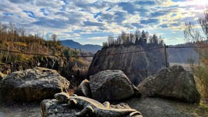 A rugged outdoor landscape with large rocks, a wooden fence, and a distant view of mountains under a partly cloudy sky. - Apartment 'Wolfswind' with Mountain View, Balcony and Wi-Fi (Langelsheim)
