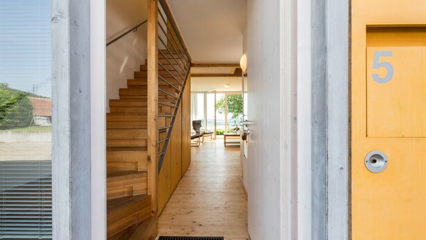 A wooden staircase leading to a room with a number '5' on the wall, a window, and a door. - Apartment '1' with Lake View, Private Terrace and Wi-Fi (Kressbronn am Bodensee)