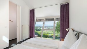 A bedroom with a large window, a bed, and a radiator. - Apartment '1' with Lake View, Private Terrace and Wi-Fi (Kressbronn am Bodensee)