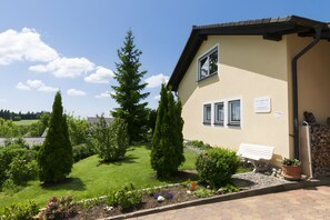 A building with a garden, a bench, and a sign. - Apartment 'Morgensonne' with Mountain View, Private Terrace and Wi-Fi (Höchenschwand)
