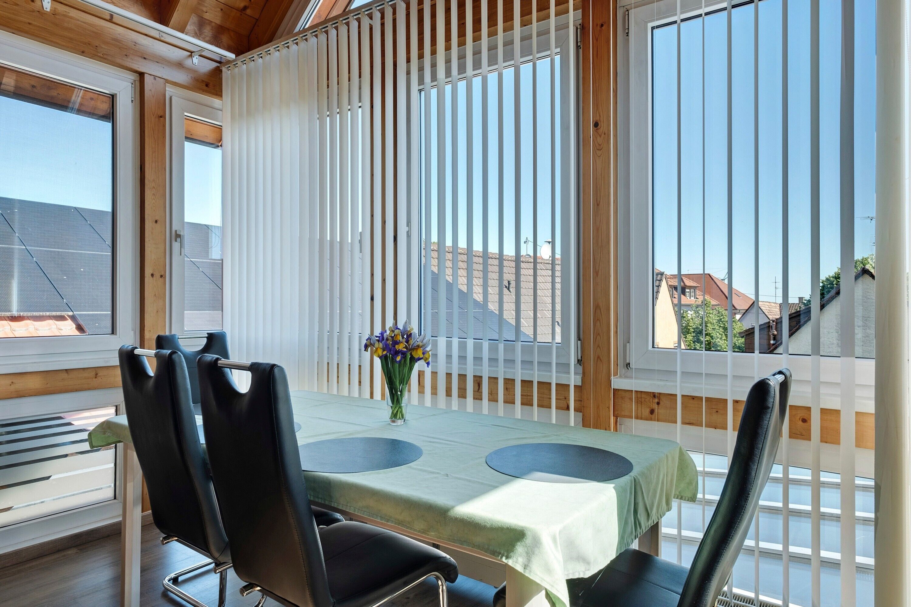Ein Essbereich mit Tisch, Stühlen und Blick durch ein Fenster.