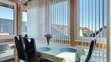 Ein Essbereich mit Tisch, Stühlen und Blick durch ein Fenster.