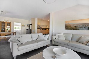 A modern living room with a sofa, a coffee table, and a painting on the wall.